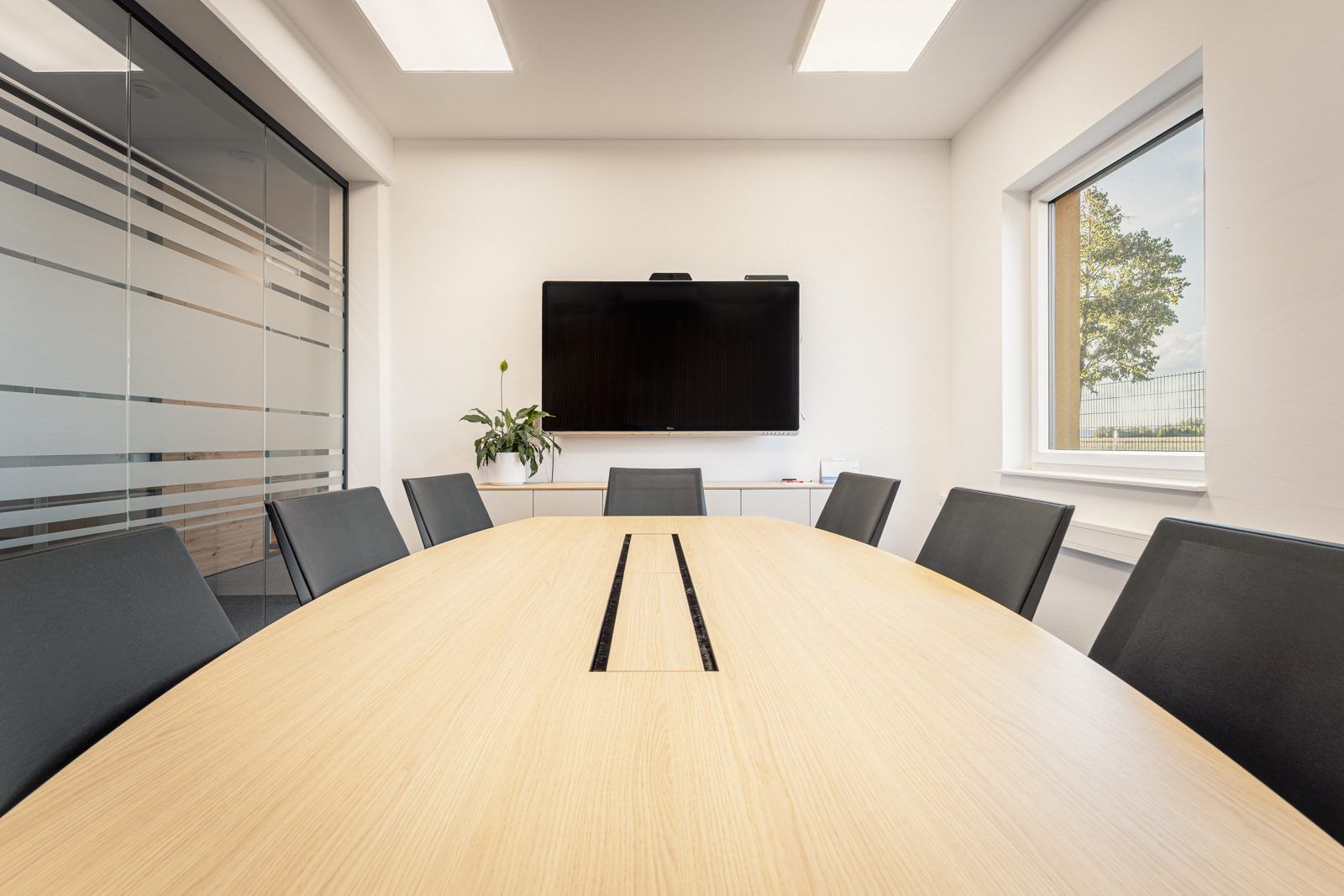 Blick über den Konferenztisch zum Bildschirm